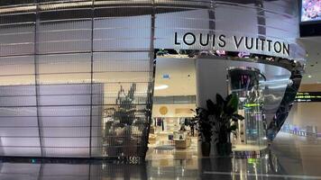 doha aeroporto Qatar 16.05.2024 Louis vuitton memorizzare negozi boutique persone in viaggio in attesa per loro aereo mossa a partire dal terminale per un altro terminale nel il riposo la zona video