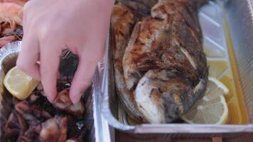 Shrimp and lemon Seafood picnic young female hand takes a piece of octopus fried in disposable containers video