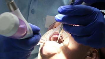 médico scans a pacientes dentes dentro a clínica. a dentista detém dentro dele mão uma manual 3d scanner para a mandíbula e boca. dental saúde. cria uma 3d modelo do dentes e gengivas em uma médico monitor. video
