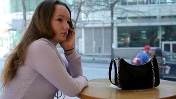 Network mobile phone girl stands on the background of a skyscraper and looks aside video