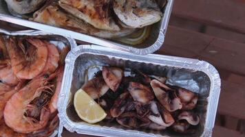 frutos do mar piquenique camarão Lula peixe servir dentro descartável containers, comer com mãos lado de fora video