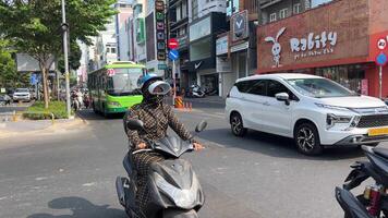 Vietnam Ho chi minh ciudad 23.05.2024 motocicleta Taxi agarrar asiático conductor toma europeo joven mujer en un viaje a moverse alrededor el ciudad video