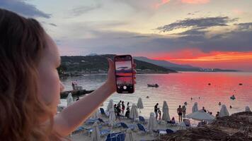 A teenage girl rests on the sea, swims in a black pareo, sits on her phone, relaxes on a luxury beach, several different videos of the travel process