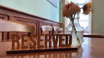 Table reservation sign in a restaurant Reserved sign on the table in restaurant. Clouse up. Plate reserved. video