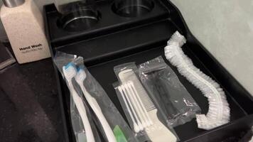 Disposable kit at the hotel. disposable set of a shower cap, a comb, a toothpaste and a brush in a hotel on an airplane is given out at expensive video