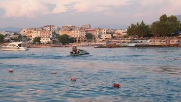 Ksamil Albania 05.22.2024 Ride a jet ski cooter jet ski people ride at a fast pace on the sea Albania Travelers vacationing video