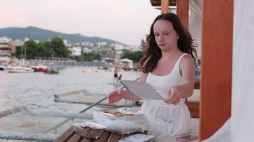 Girl on the beach having dinner alone Seafood picnic shrimp squid fish Serve in disposable containers, eat with hands outside video