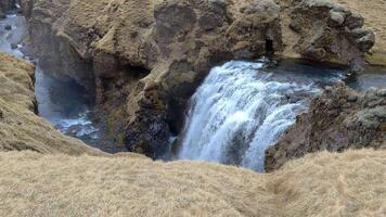 An ethereal landscape of grey fields contrasted with white and blue waterfalls. video