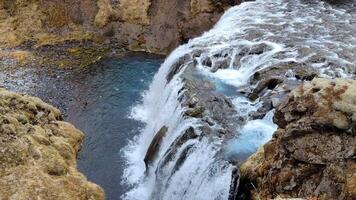 un aéreo ver de un maravilloso azul agua cascada en Islandia video