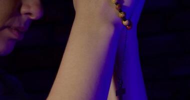 Close up of female hands praying in a dark room video