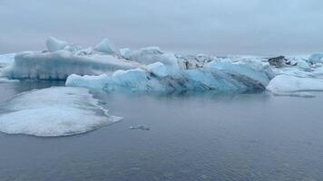 un' sereno ancora vita di un' ghiacciaio lago con blu cristallo ghiaccio galleggiante nel suo chiaro acque. video