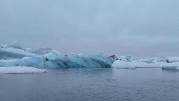 A tranquil still life of blue crystal ice floating in a glacier lake. video