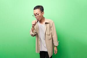 man in tan jacket having cough or influenza isolated on green background photo
