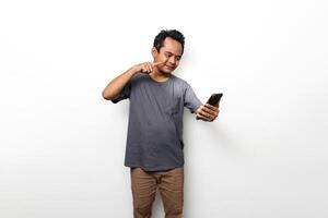 Asian man in gray is pointing at smartphone photo