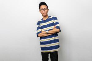 A handsome asian man in a striped shirt and glasses is crossing his arms photo