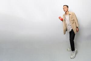 an asian man with a tan jacket is lifting dumbbells for muscle training or fitness photo