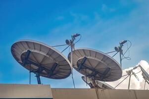 two large parabolic antennas on the roof with blue sky background photo
