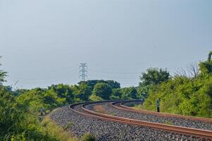 Double track railway bends between bushes photo