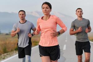 A group of friends, athletes, and joggers embrace the early morning hours as they run through the misty dawn, energized by the rising sun and surrounded by the tranquil beauty of nature photo