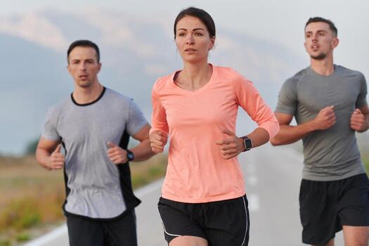 A group of friends, athletes, and joggers embrace the early morning hours as they run through the misty dawn, energized by the rising sun and surrounded by the tranquil beauty of nature photo