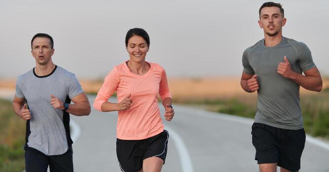A group of friends, athletes, and joggers embrace the early morning hours as they run through the misty dawn, energized by the rising sun and surrounded by the tranquil beauty of nature photo