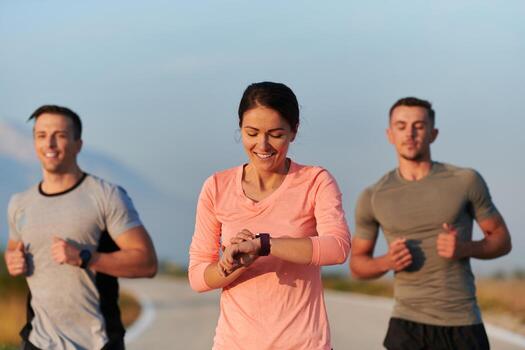 A group of friends, athletes, and joggers embrace the early morning hours as they run through the misty dawn, energized by the rising sun and surrounded by the tranquil beauty of nature photo