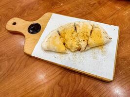 a pizza on a wooden cutting board. suitable for Italian food menu content photo