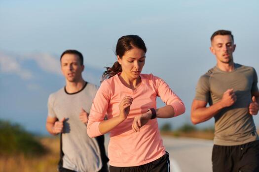 A group of friends, athletes, and joggers embrace the early morning hours as they run through the misty dawn, energized by the rising sun and surrounded by the tranquil beauty of nature photo