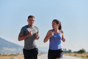 energizado por el belleza de naturaleza, un Pareja potestades mediante su Mañana correr, su cuerpos y espíritu revitalizado. foto