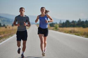 energizado por el belleza de naturaleza, un Pareja potestades mediante su Mañana correr, su cuerpos y espíritu revitalizado. foto