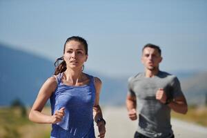 energizado por el belleza de naturaleza, un Pareja potestades mediante su Mañana correr, su cuerpos y espíritu revitalizado. foto