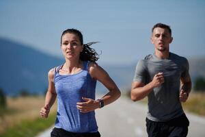 energizado por el belleza de naturaleza, un Pareja potestades mediante su Mañana correr, su cuerpos y espíritu revitalizado. foto