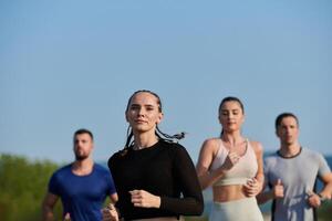 A group of friends maintains a healthy lifestyle by running outdoors on a sunny day, bonding over fitness and enjoying the energizing effects of exercise and nature photo