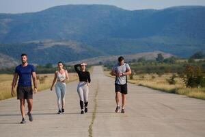 un grupo de amigos mantiene un sano estilo de vida por corriendo al aire libre en un soleado día, unión terminado aptitud y disfrutando el energizante efectos de ejercicio y naturaleza foto