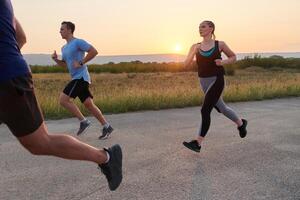 A diverse group of runners trains together at sunset. photo