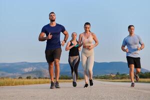 un grupo de amigos mantiene un sano estilo de vida por corriendo al aire libre en un soleado día, unión terminado aptitud y disfrutando el energizante efectos de ejercicio y naturaleza foto