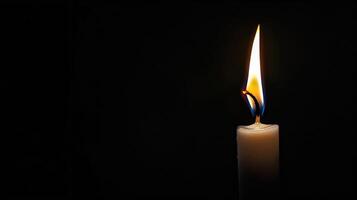 Burning white candle on black background. Close-up photo. With copy space. Image for memory of events and people photo