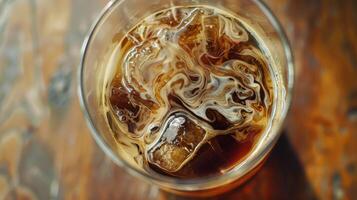 Iced cold brew coffee with cream swirling photo