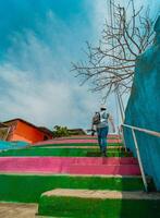 Man climbing multicolored steps. Rear view of a person climbing stairs, Nagarote. photo