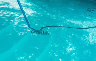 piscina mantenimiento y limpieza con vacío manguera. limpieza nadando piscina con succión manguera foto