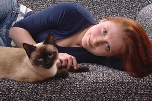 young woman with siamese cat photo