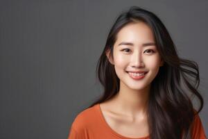 Gorgeous young asian woman in an orange top smiling photo