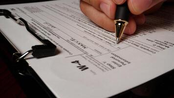 17 photo hispanic male hand filling out writing w4 irs tax employee form
