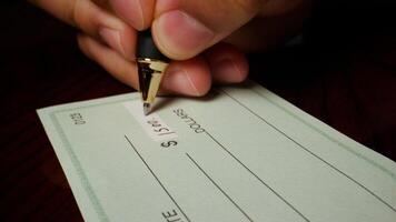 1 photo hispanic male hand filling out writing blank check