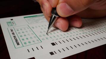 2 photo hispanic male hand filling out writing exam test form