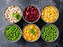 Opened tins of canned corn, green peas, red and white beans. Aesthetic macro photo, texture background photo