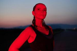 Athlete Strikes a Pose in Red-Lit Nighttime Glow photo
