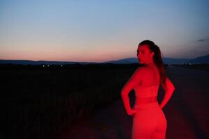 Athlete Strikes a Pose in Red-Lit Nighttime Glow photo