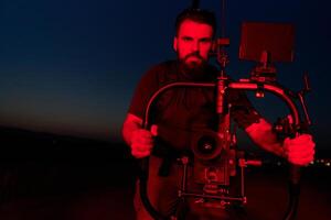 Noche captura. profesional camarógrafo Película (s Atletas corriendo en iluminado en rojo oscuridad foto