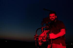 Noche captura. profesional camarógrafo Película (s Atletas corriendo en iluminado en rojo oscuridad foto